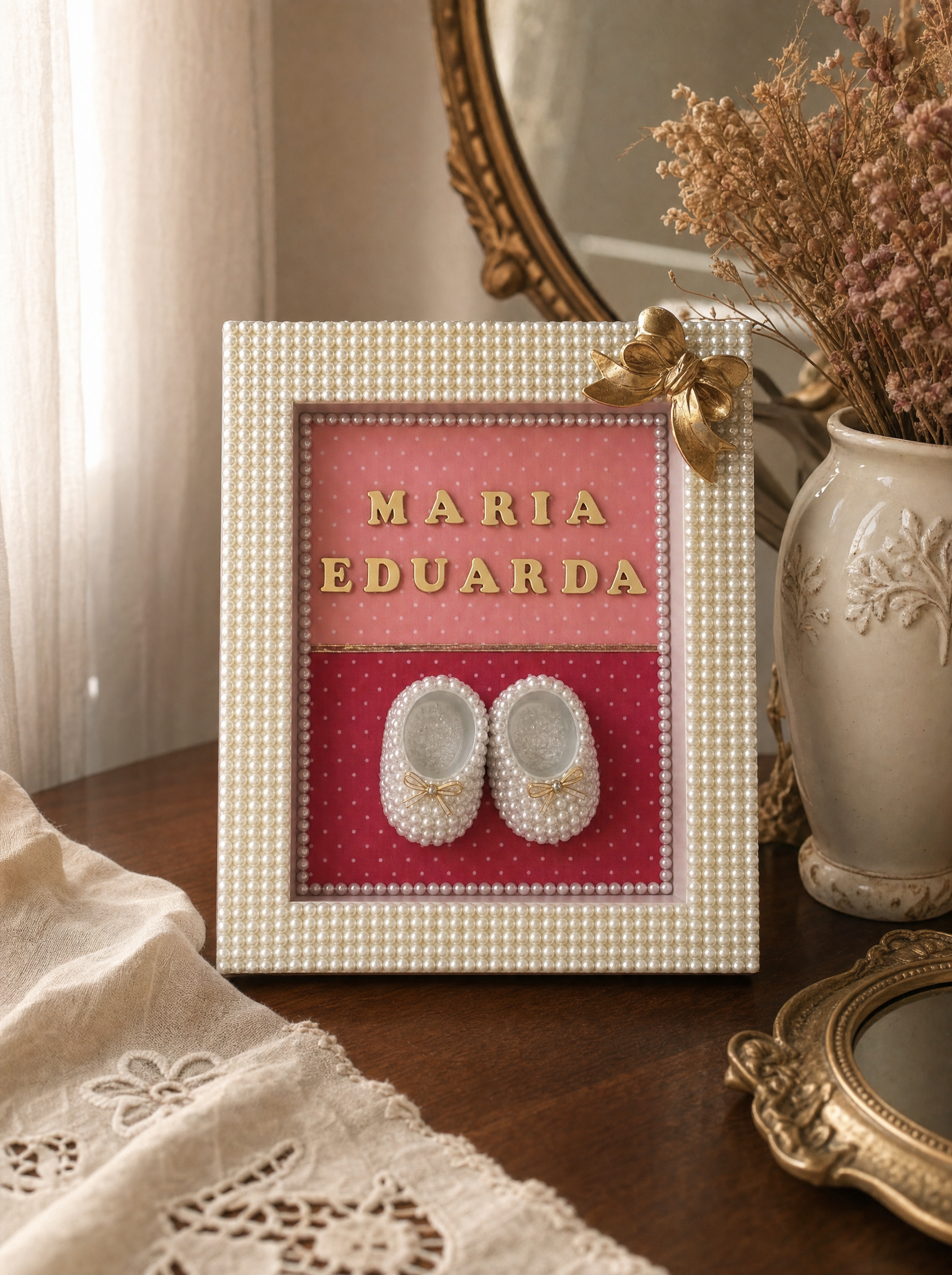 Quadro maternidade Maria Eduarda em escrivaninha vintage com espelho dourado e vaso de flores secas