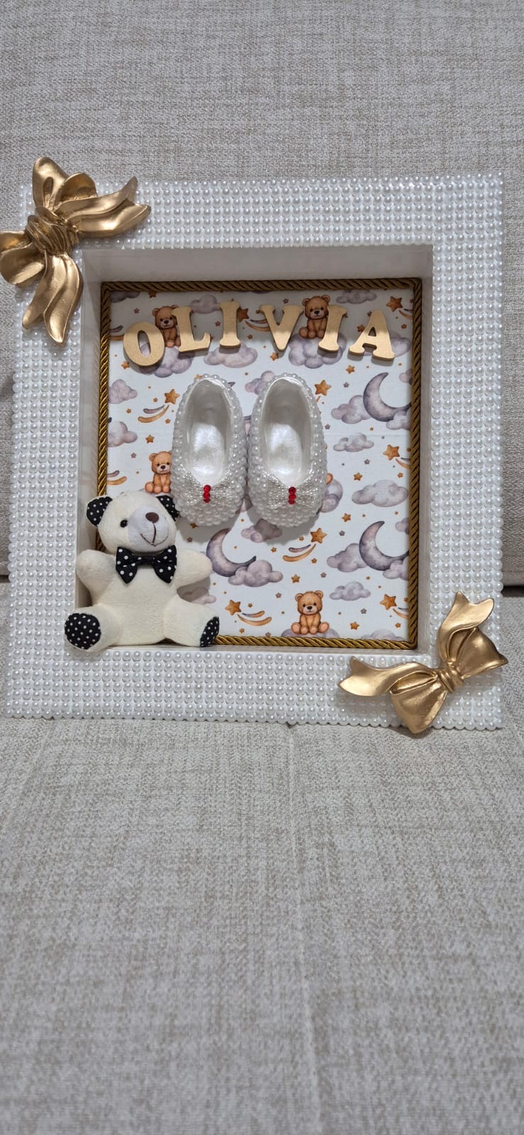 Quadro maternidade Olivia — fundo de nuvens e estrelas, laços dourados e ursinho